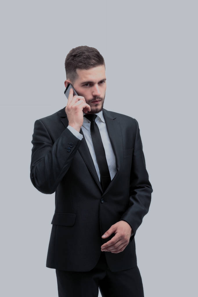 Красивый бизнесмен в костюме пользуется телефоном в офисе
 - Фото, изображение