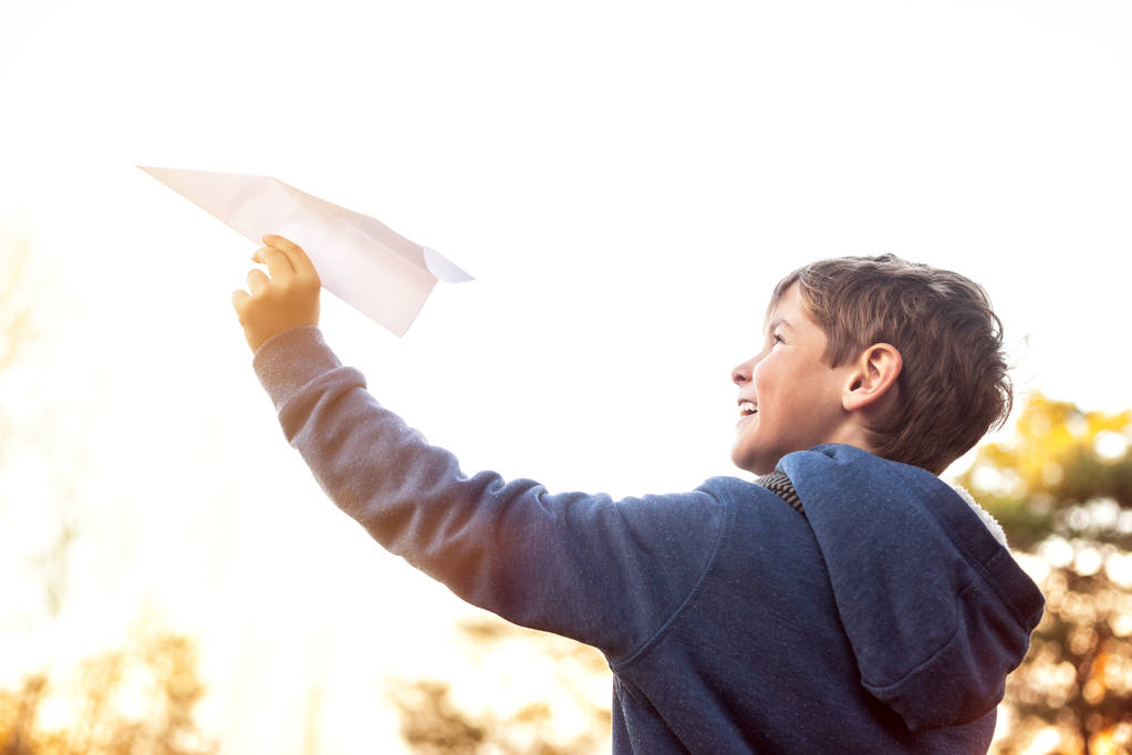 Little boy playing with a paper airplane on a sunny Autumn day, Outdoors - Photo, Image