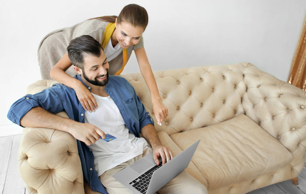 Jong (echt) paar met laptop thuis. Internet shopping concept - Foto, afbeelding