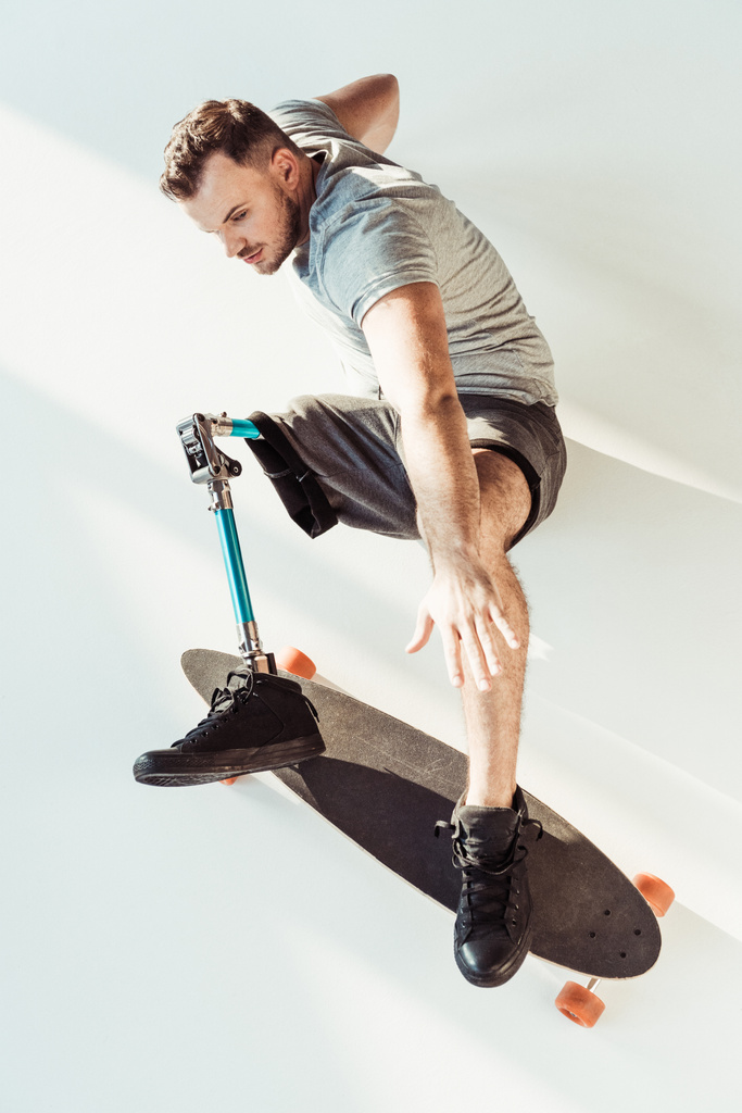 hombre con prótesis de pierna con monopatín
 - Foto, Imagen