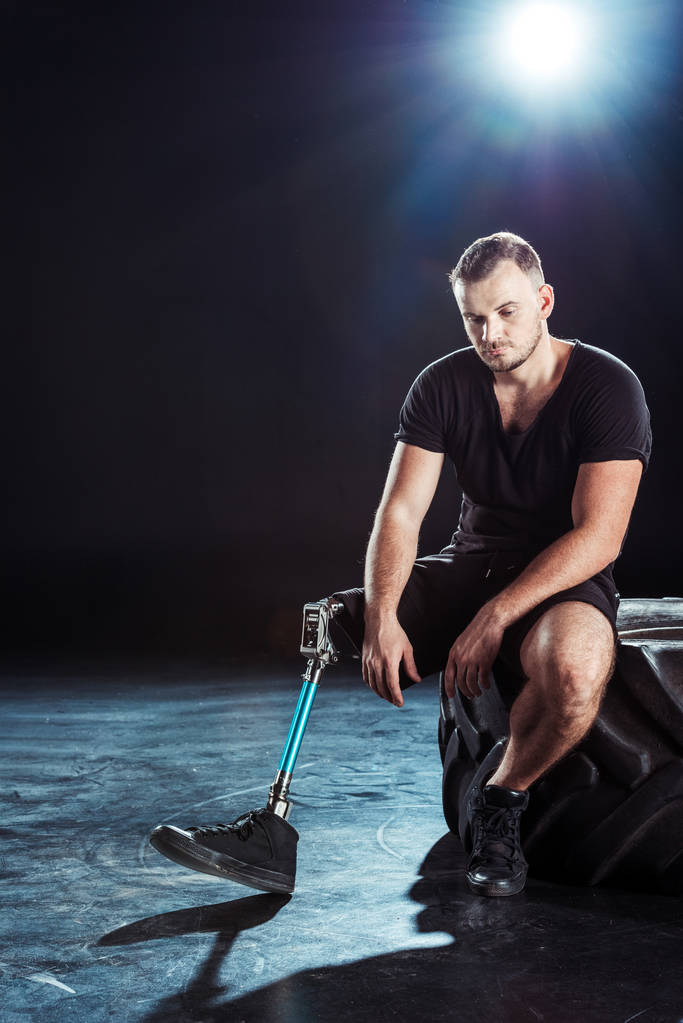 deportista paralímpico descansando sobre un neumático
 - Foto, Imagen