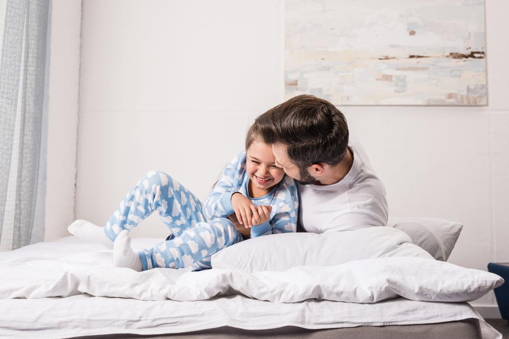 отец и дочь обнимаются в постели
 - Фото, изображение