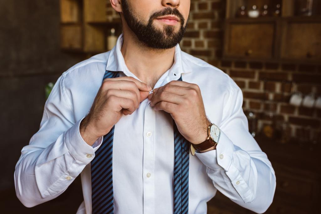 hombre de negocios botones de fijación en la camisa
 - Foto, Imagen