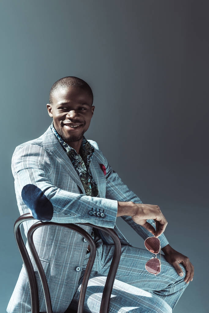 Homem americano africano elegante sentado na cadeira
 - Foto, Imagem