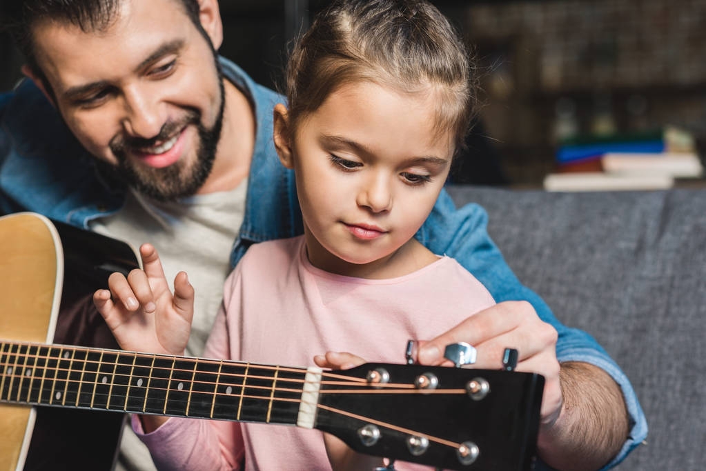 father learning daughter to play guitar - Photo, Image