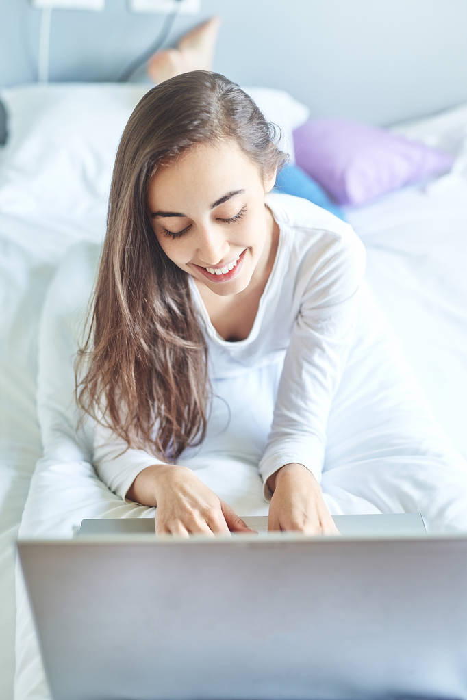 Młoda kobieta uśmiechający się z laptopa - Zdjęcie, obraz