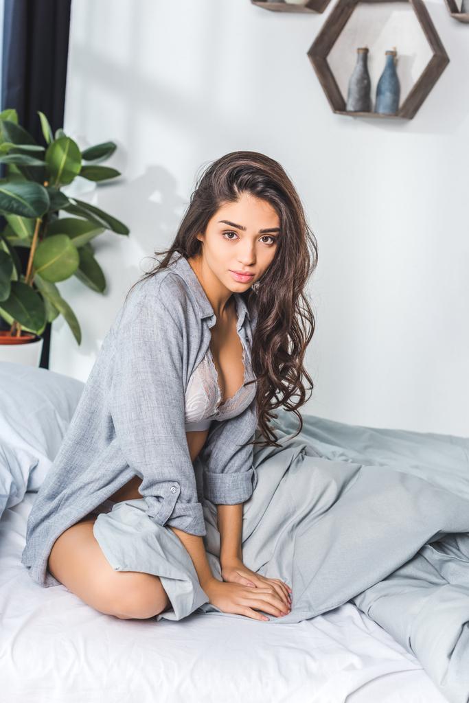 Seksikäs nainen istuu sängyllä
 - Valokuva, kuva