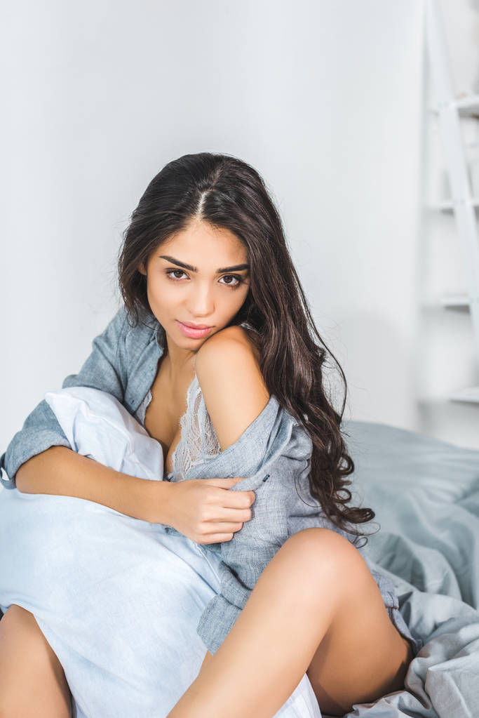 Seksikäs nainen istuu sängyllä
 - Valokuva, kuva