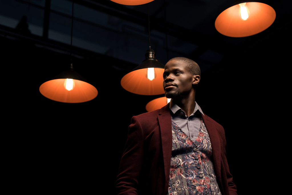 афроамериканський чоловік у темній кімнаті з лампами
 - Фото, зображення
