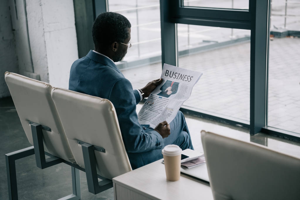 uomo d'affari che legge il giornale in aeroporto
 - Foto, immagini