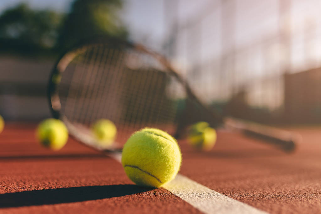 Bolas e raquete no campo de ténis
 - Foto, Imagem
