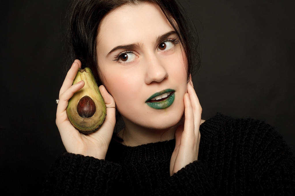 ritratto di attraente donna caucasica sorridente con avocado
 - Foto, immagini