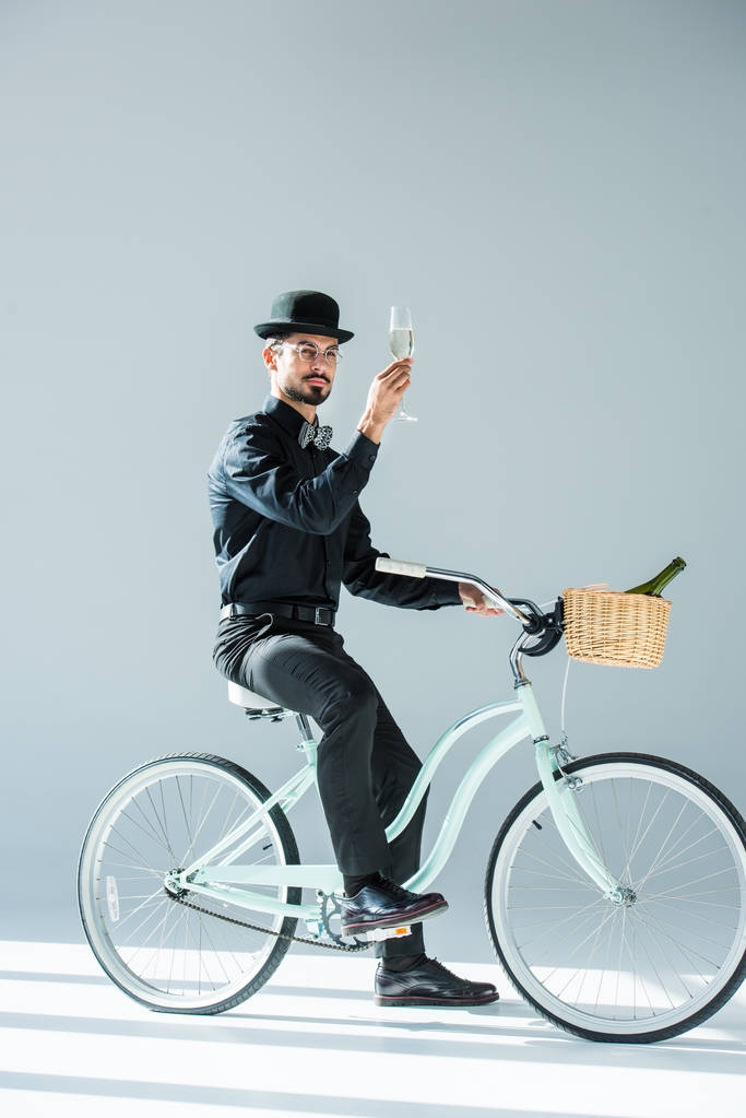 ο άνθρωπος στο ρετρό ποδήλατο με ποτήρι σαμπάνια - Φωτογραφία, εικόνα