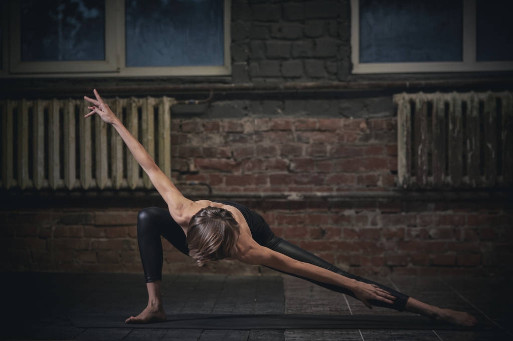 Красива спортивна підгонка йога жінка практикує йогу асану в темній залі
 - Фото, зображення