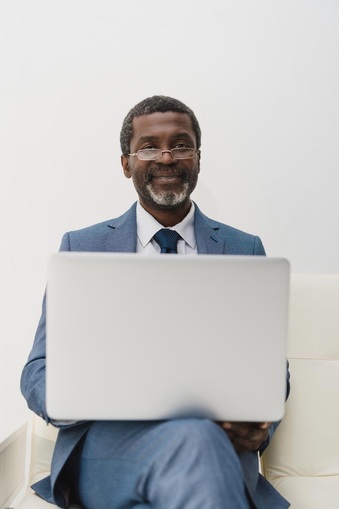 Sonriente hombre trabajando con el ordenador portátil
 - Foto, imagen