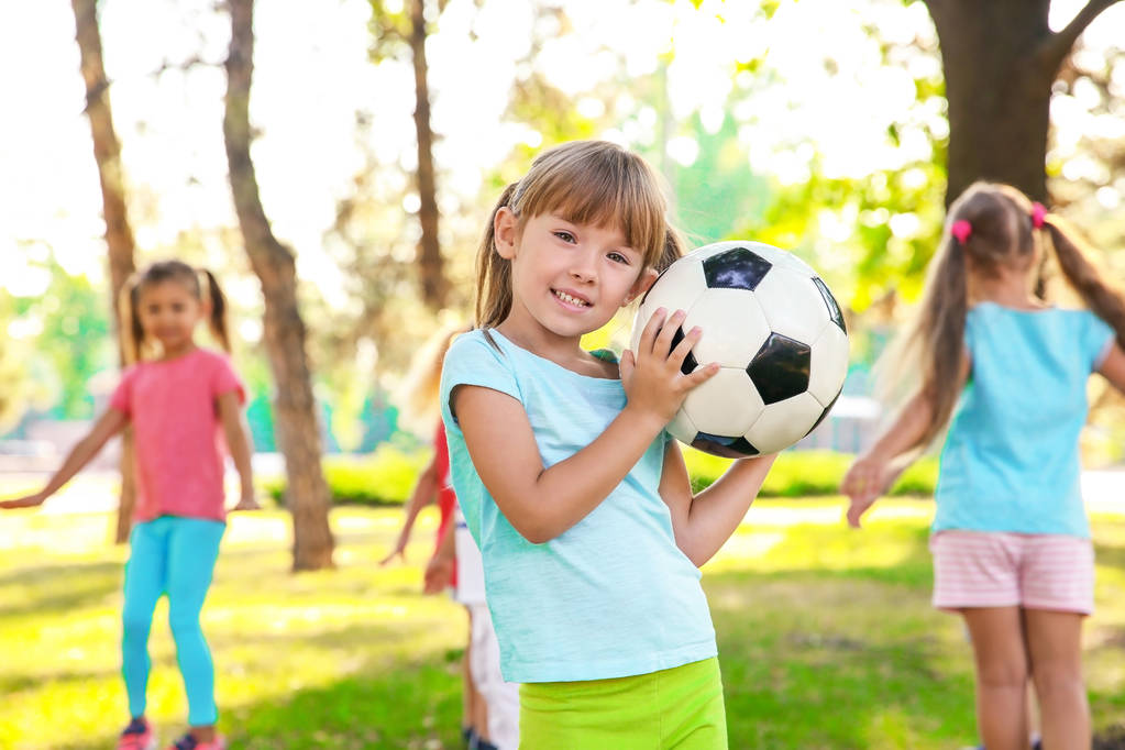 Petite fille mignonne jouant au ballon avec d'autres enfants dans le parc
 - Photo, image