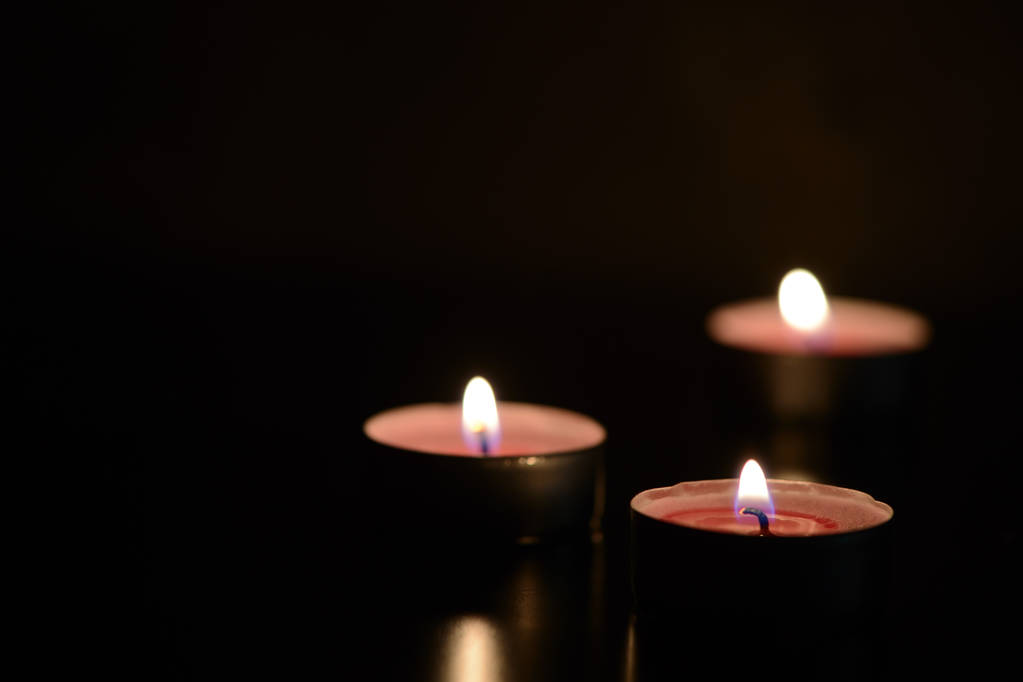 Tres velas encendidas en la oscuridad
 - Foto, Imagen