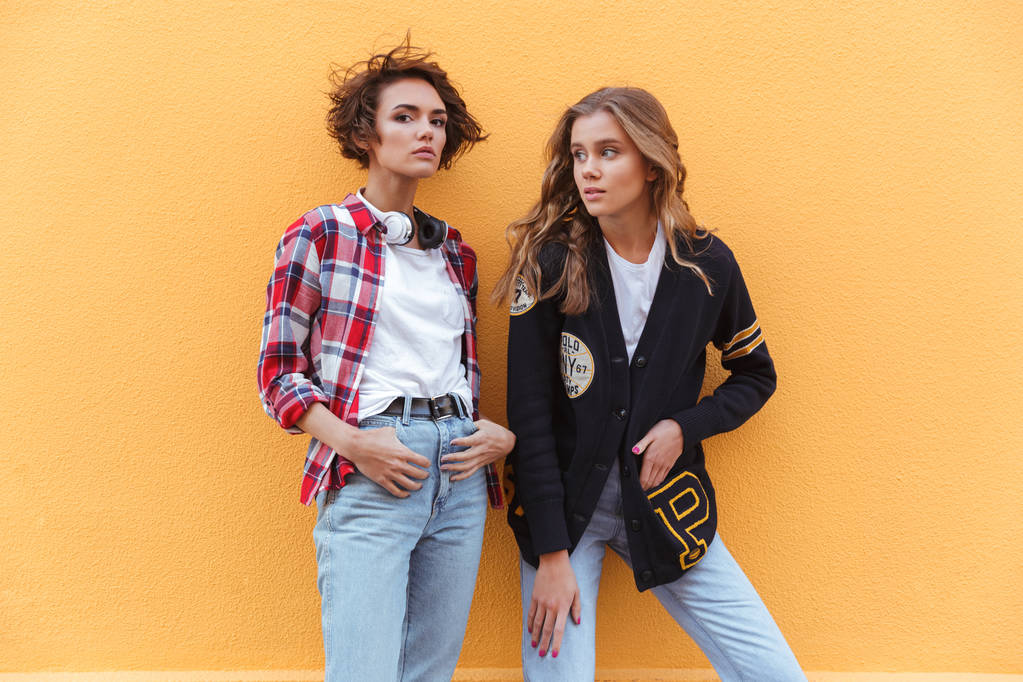 Две стильные девушки-подростки позируют стоя
 - Фото, изображение