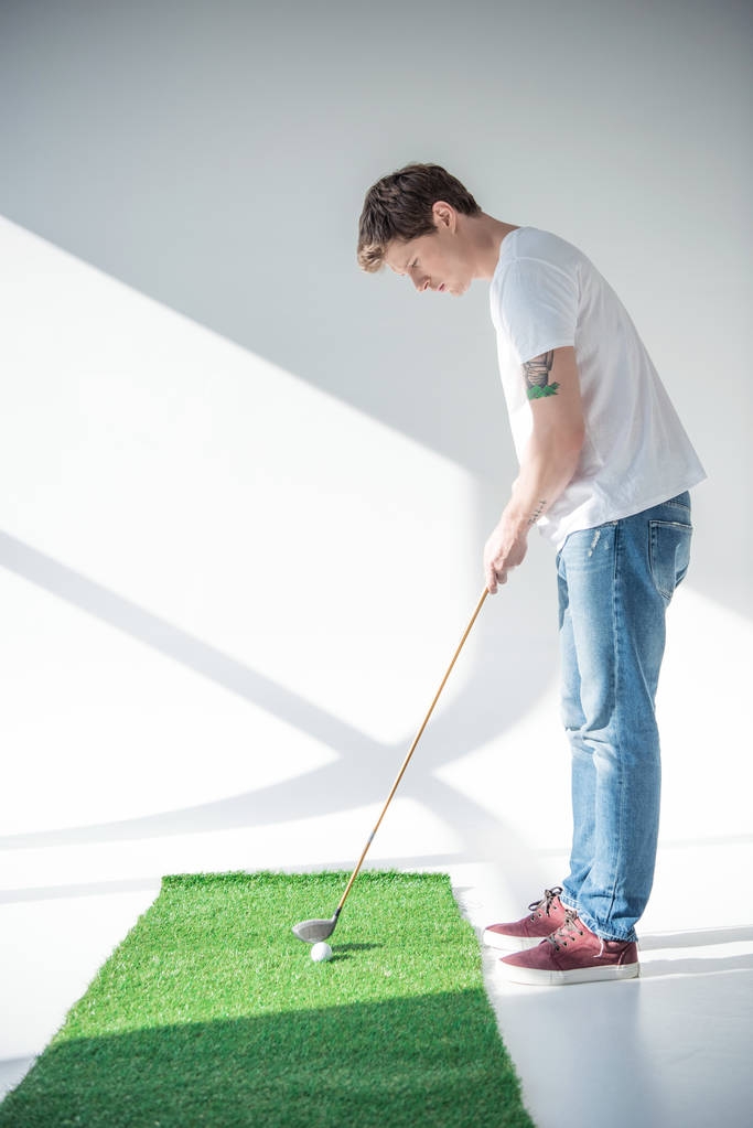 молодий чоловік грає в гольф
 - Фото, зображення
