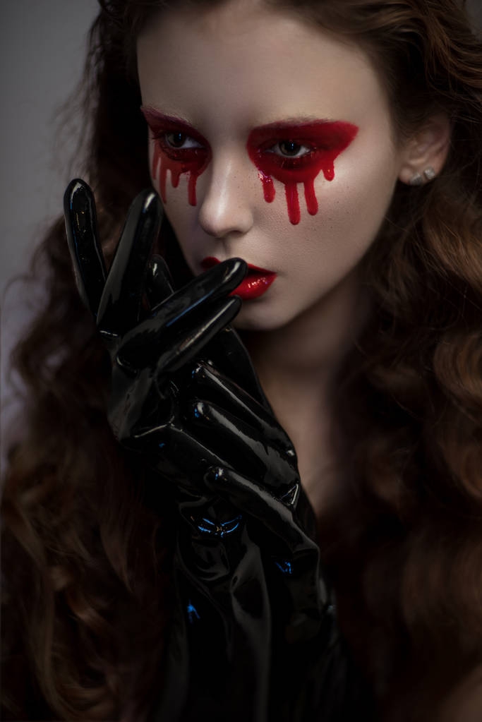 γυναίκα με αιματηρές μάτια και γάντια από λάτεξ - Φωτογραφία, εικόνα