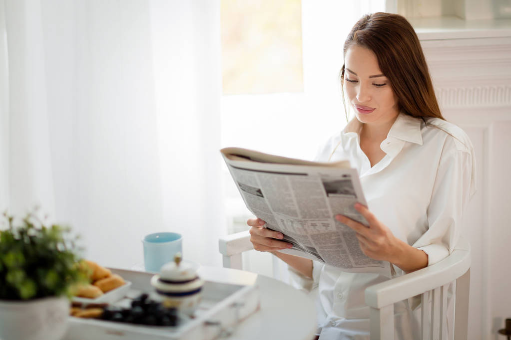 Молода красива жінка читає журнал
 - Фото, зображення