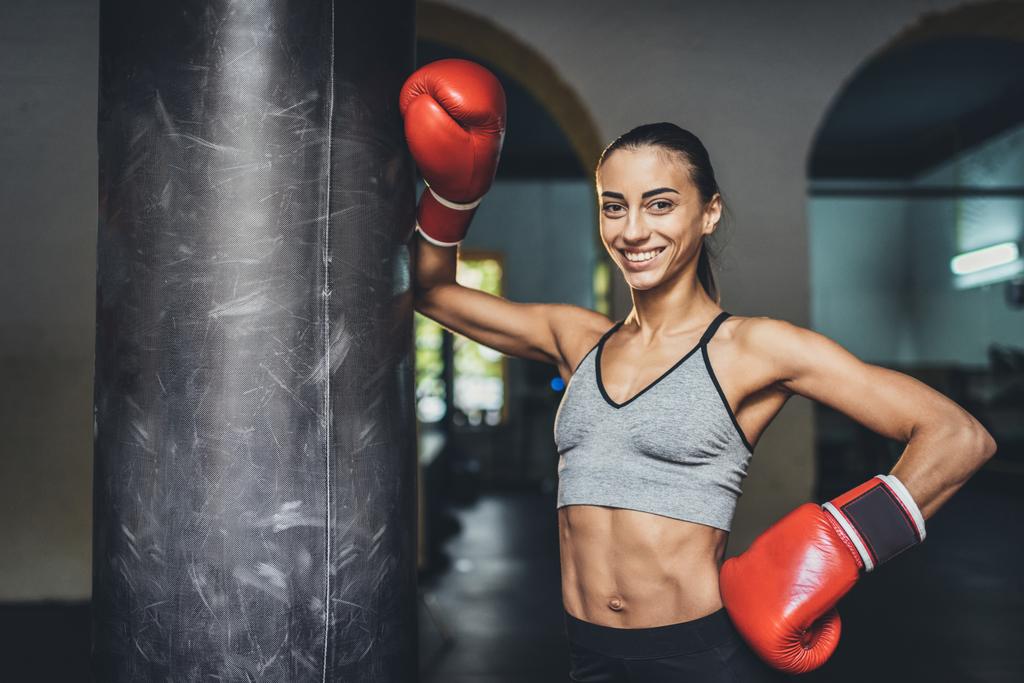 Boxeador femenino con saco de boxeo
 - Foto, Imagen