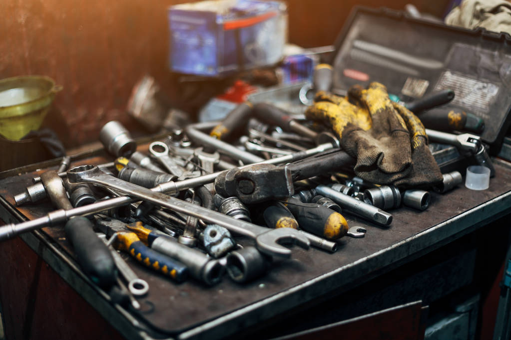 Προστατευτικά γάντια, σφυρί, γαλλικά κλειδιά, κλπ. Closeup μηχανικός στο χώρο εργασίας - Φωτογραφία, εικόνα