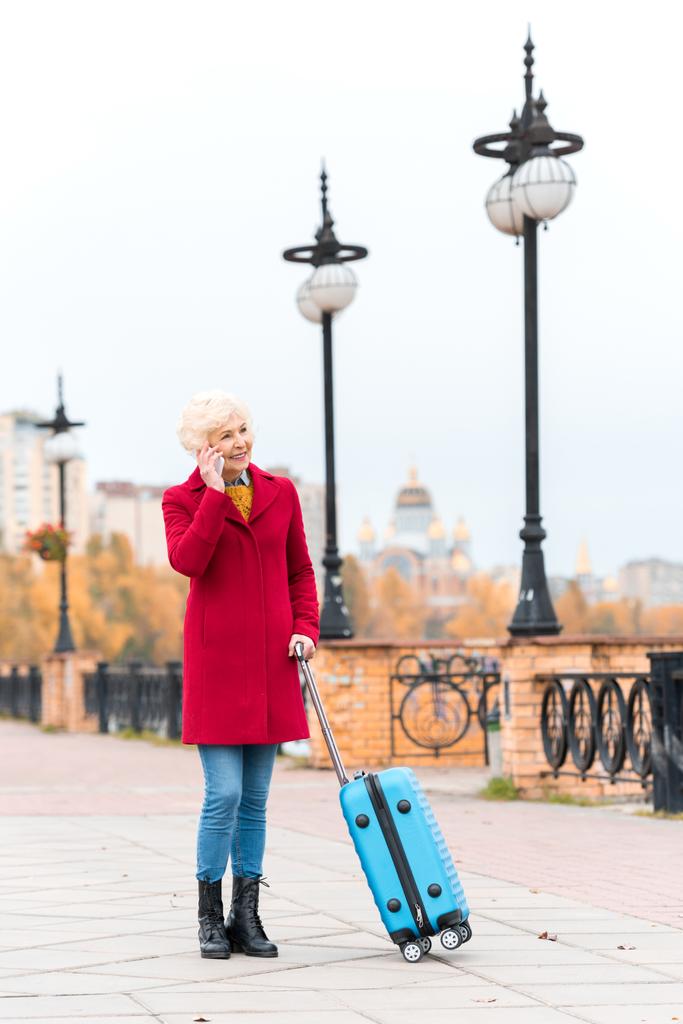 senior woman with suitcase and smartphone - Photo, Image
