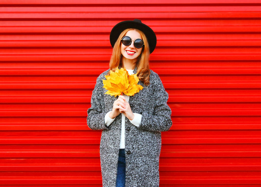 Mode najaar lachende vrouw met gele maple laat op colorfu - Foto, afbeelding