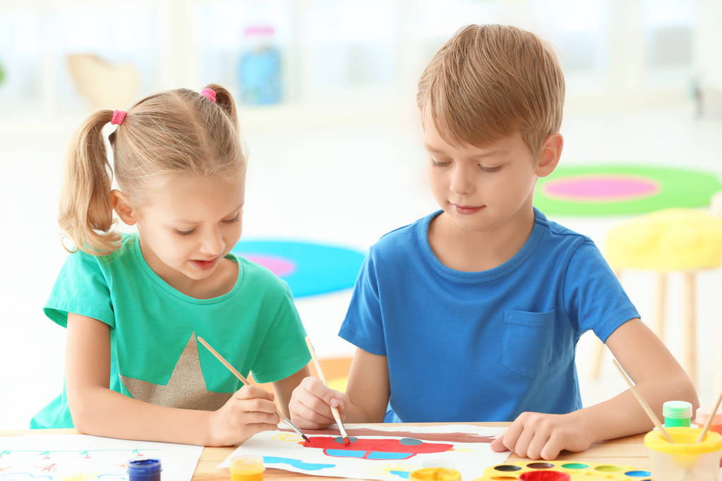 Χαριτωμένα παιδιά ζωγραφική στο τραπέζι σε εσωτερικούς χώρους - Φωτογραφία, εικόνα