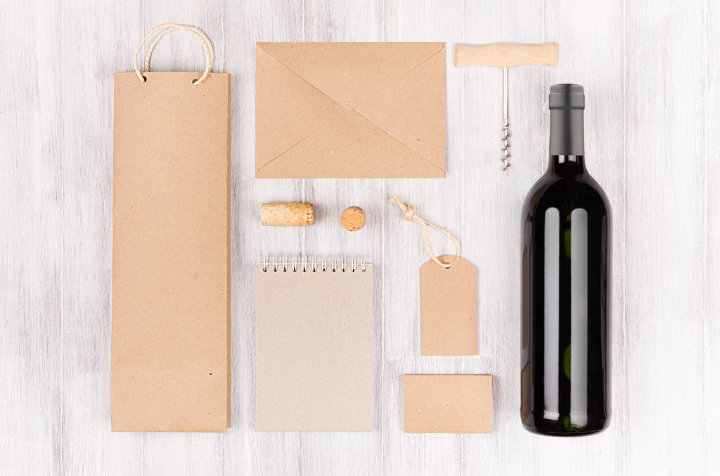 ワイン業界、空白の茶色のクラフト包装、文房具、柔らかい白いウッドの背景上のボトル赤ワインで設定商品の企業 id テンプレート.  - 写真・画像