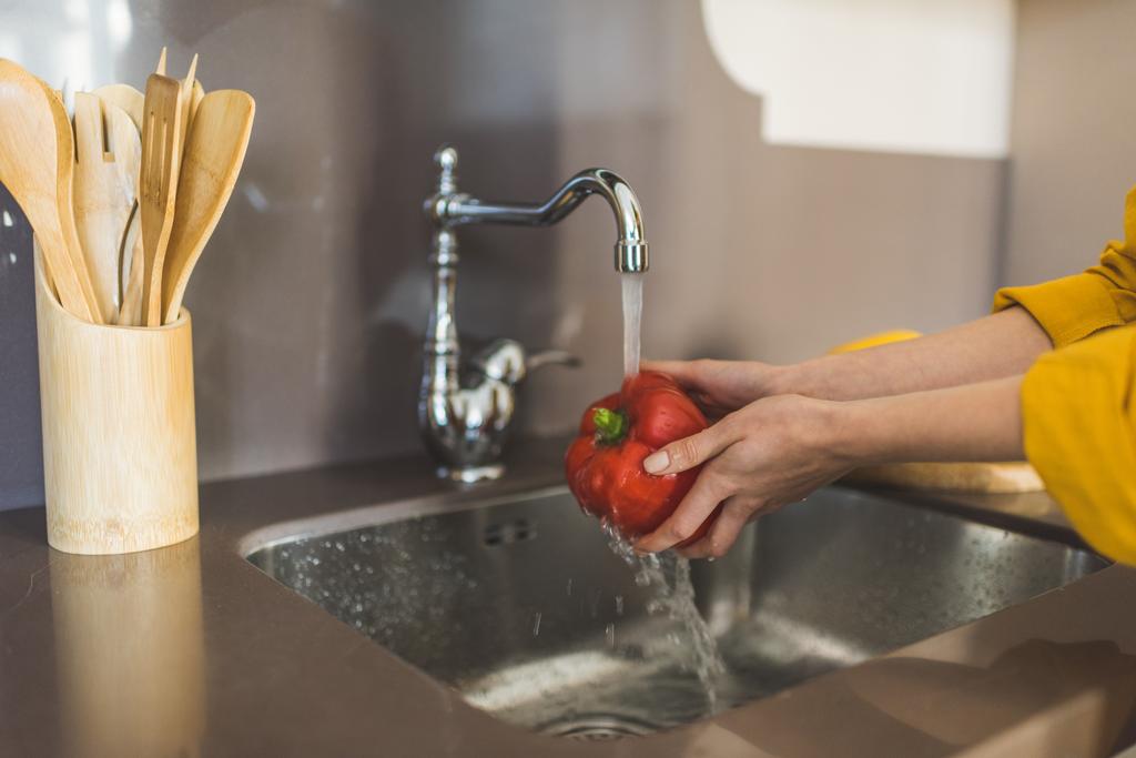 Mujer lavando pimiento rojo
 - Foto, Imagen
