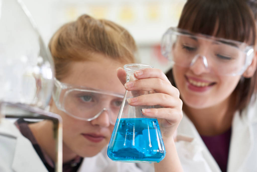 Kobiece uczeń i nauczyciel przeprowadzający eksperyment chemia - Zdjęcie, obraz