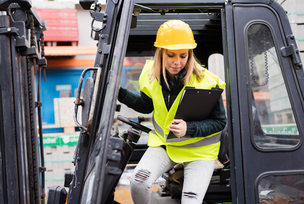 Female forklift truck driver outside a warehouse. - Photo, Image