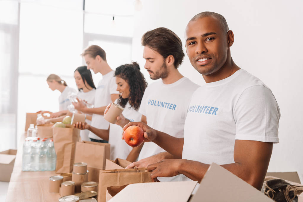 volunteer packing food into bag - Photo, Image