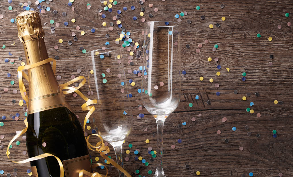 Foto de dos copas, botella de champán, confeti
 - Foto, imagen