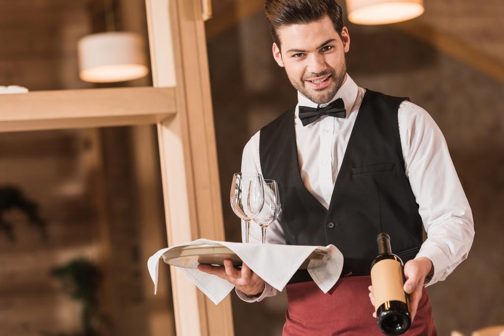 Kellner hält Weingläser und Flasche - Foto, Bild