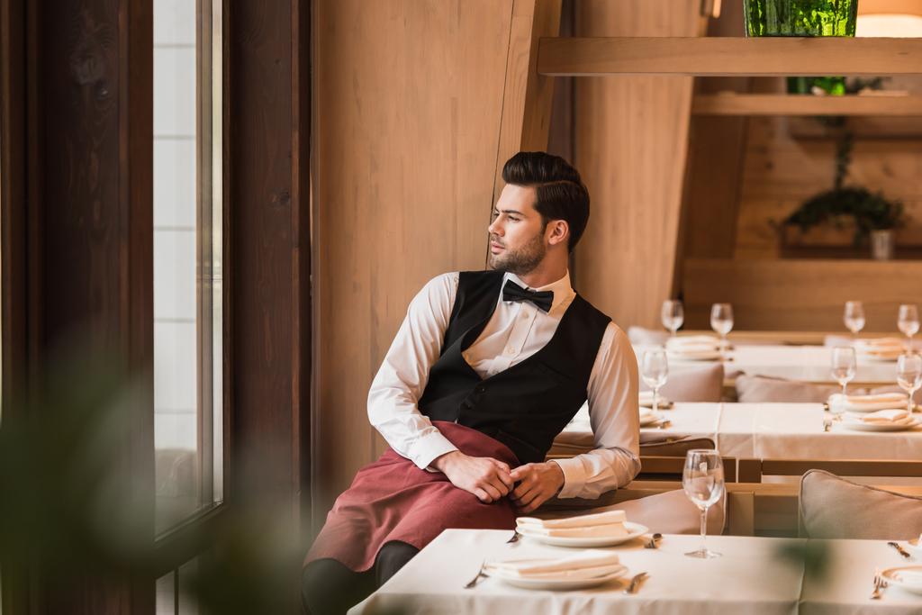 Waiter leaning on chair - Photo, Image