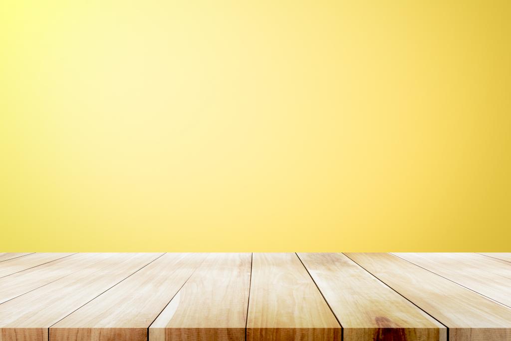 Empty wooden deck table over yellow wallpaper background. - Photo, Image