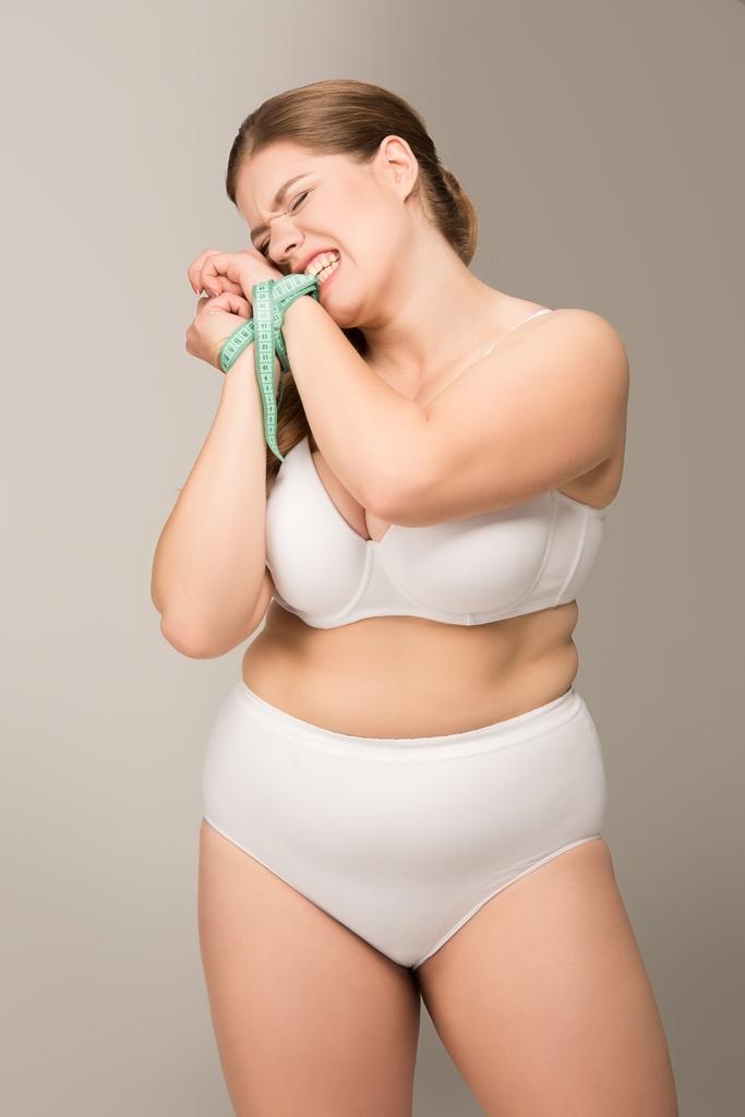 mujer con sobrepeso atada con cinta métrica
 - Foto, imagen