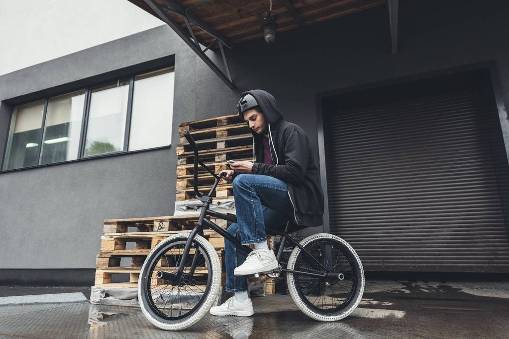 BMX kerékpáros használ smartphone    - Fotó, kép