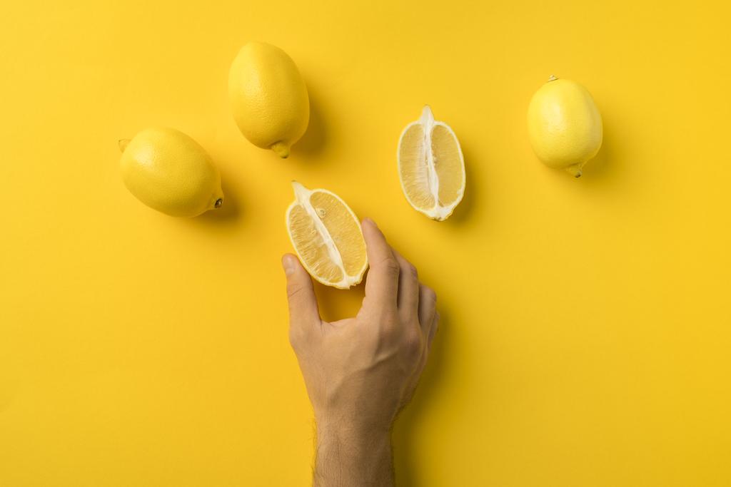 uomo con in mano metà limone
 - Foto, immagini