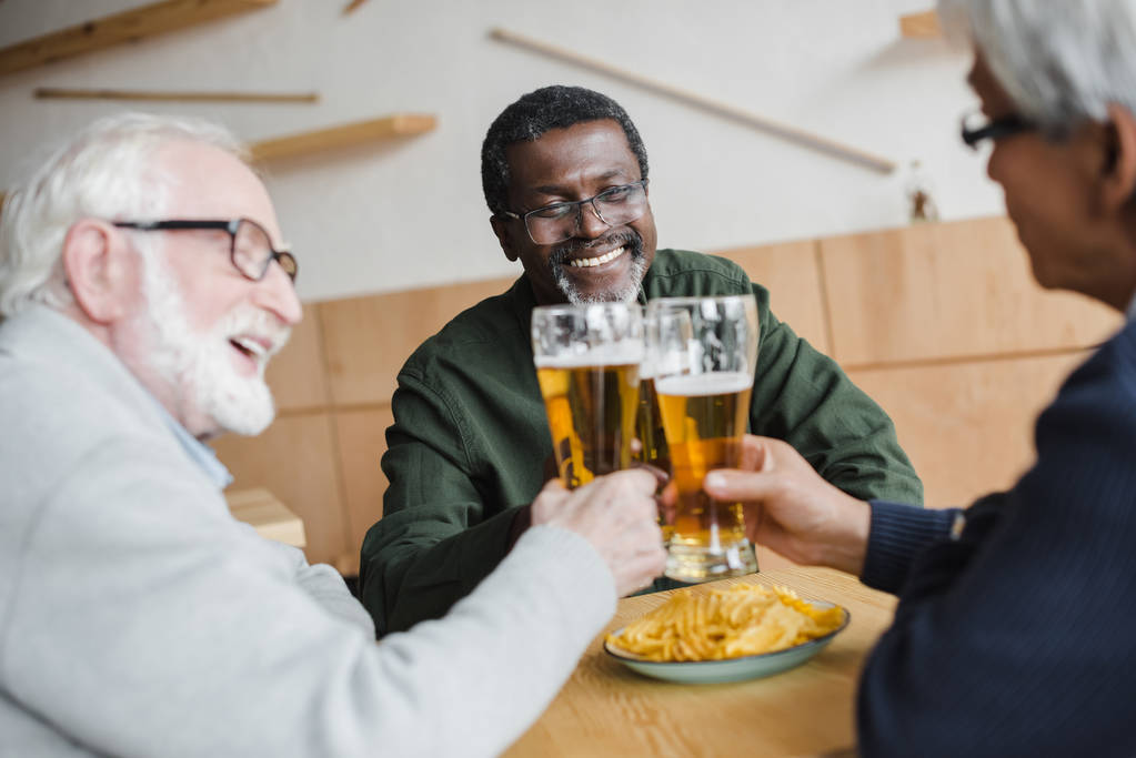 Senior vrienden rammelende glazen bier - Foto, afbeelding
