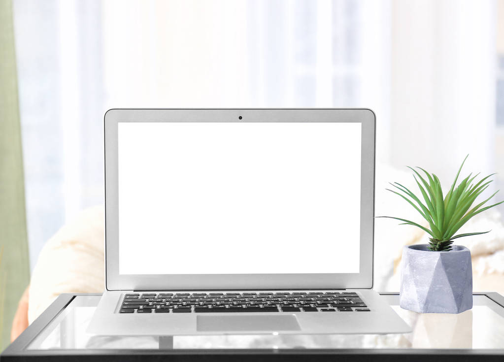 Moderne laptop met blanco scherm op tafel thuis - Foto, afbeelding
