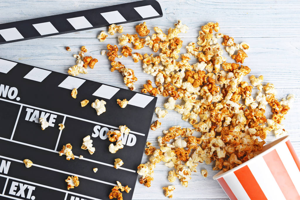 Pohárek s karamelový popcorn a filmové klapky  - Fotografie, Obrázek