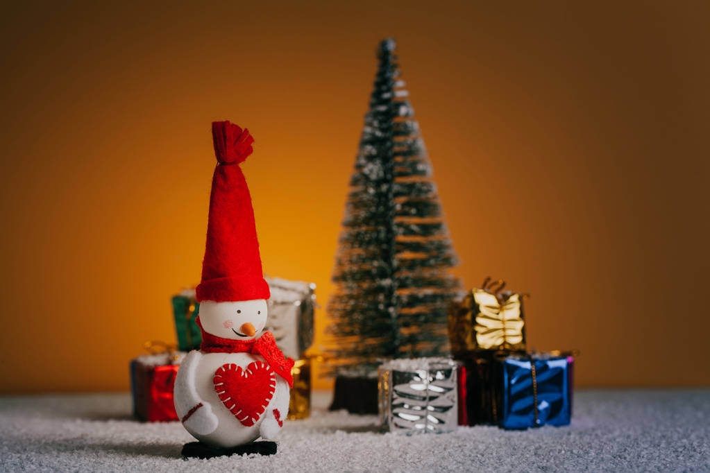 Schneemann, Weihnachtsbaum und Geschenke auf schneebedecktem Boden. - Foto, Bild