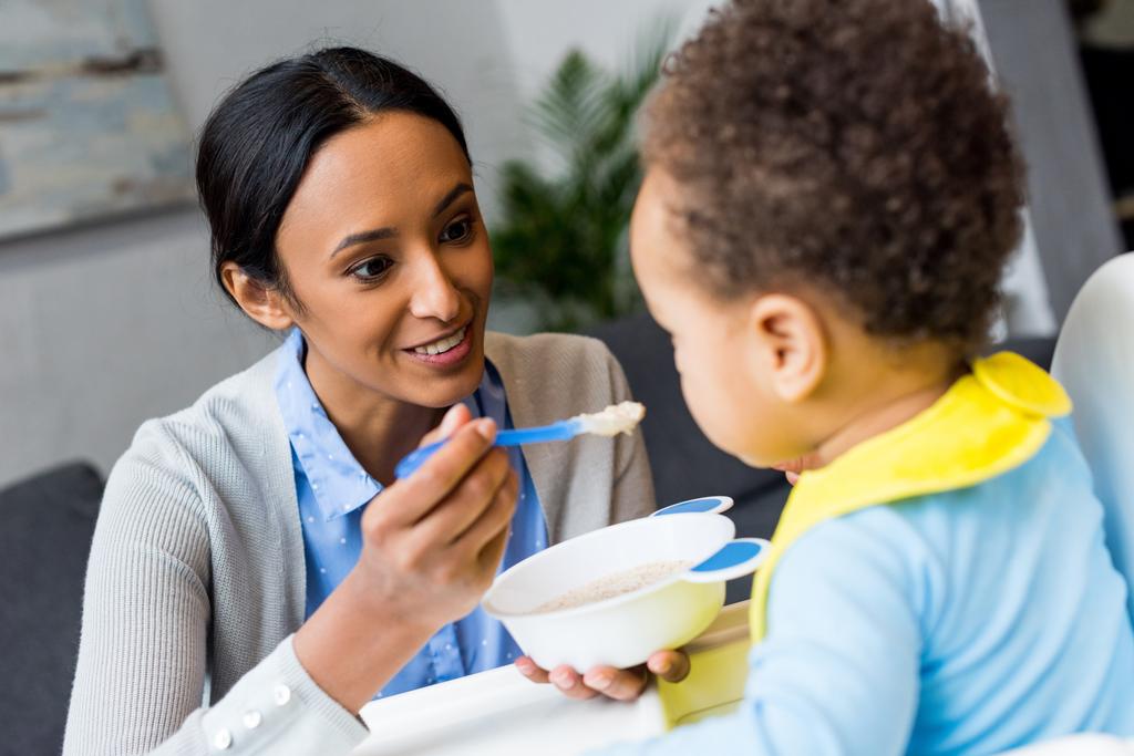 афроамериканська мати годує дитину
 - Фото, зображення