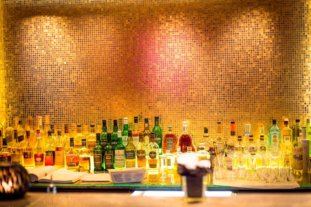 Bar met flessen op houten achtergrond - Foto, afbeelding