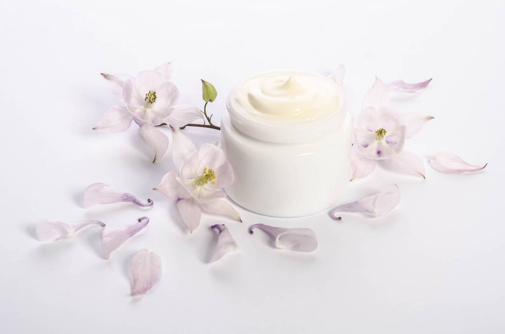 Lindas flores y pétalos y un frasco de crema corporal natural
 - Foto, imagen