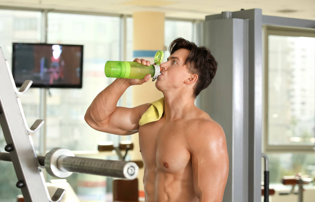 Musculoso joven beber agua
  - Foto, imagen